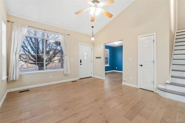 foyer featuring baseboards, visible vents, light wood-style flooring, ceiling fan, and stairs