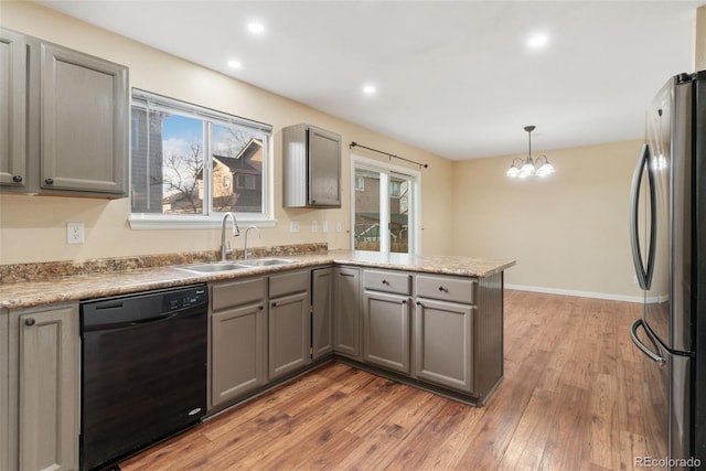 kitchen featuring gray cabinets, freestanding refrigerator, black dishwasher, and a sink