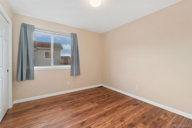 spare room with wood finished floors and baseboards