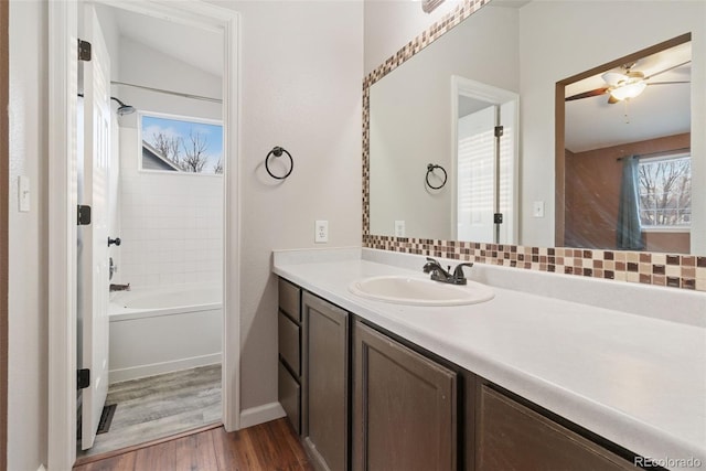 full bath featuring washtub / shower combination, wood finished floors, and vanity