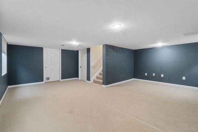 finished basement with stairs, light carpet, and baseboards