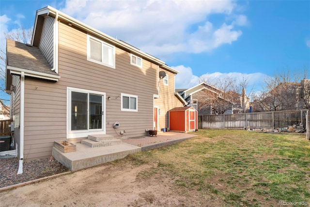 rear view of house featuring a lawn, a patio area, a shed, a fenced backyard, and an outdoor structure