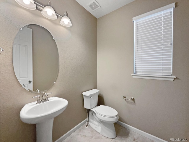 bathroom with toilet and tile patterned flooring