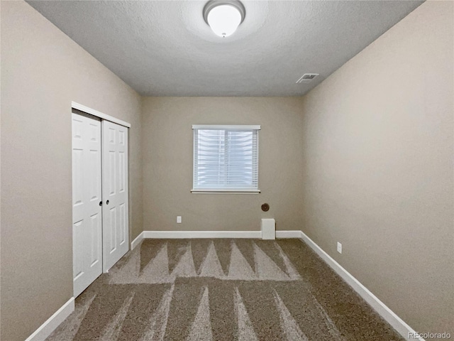 unfurnished bedroom with a closet, carpet, and a textured ceiling