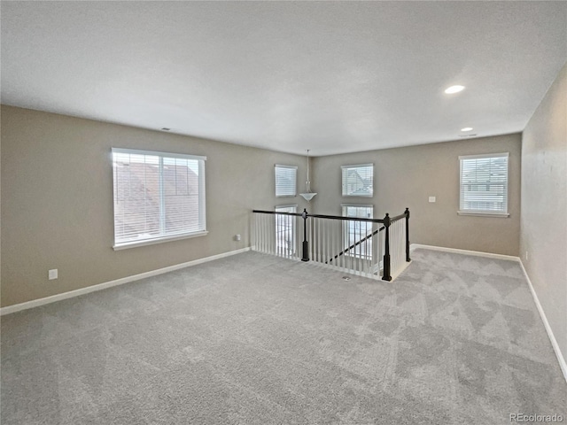 unfurnished room featuring light carpet and a wealth of natural light