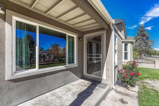 view of exterior entry with a patio