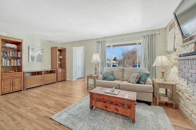 living room featuring light wood-type flooring and a textured ceiling