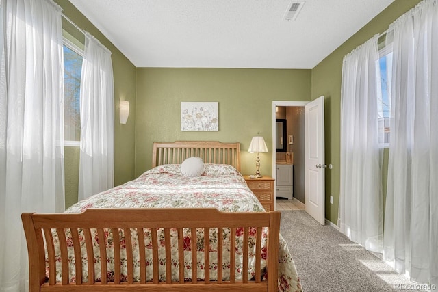 carpeted bedroom featuring multiple windows and a textured ceiling