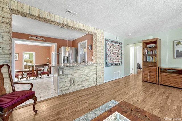 living area with light hardwood / wood-style flooring and a textured ceiling