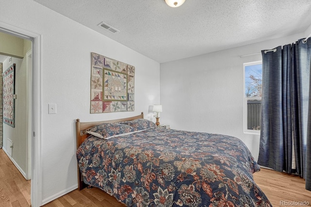 bedroom featuring hardwood / wood-style flooring and a textured ceiling