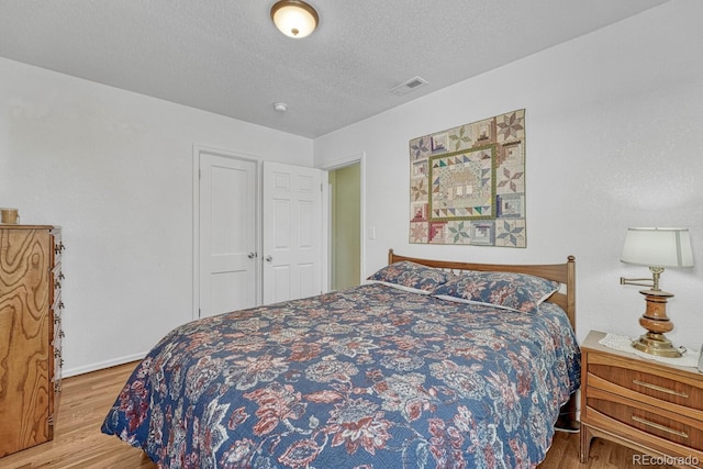 bedroom featuring hardwood / wood-style floors and a textured ceiling