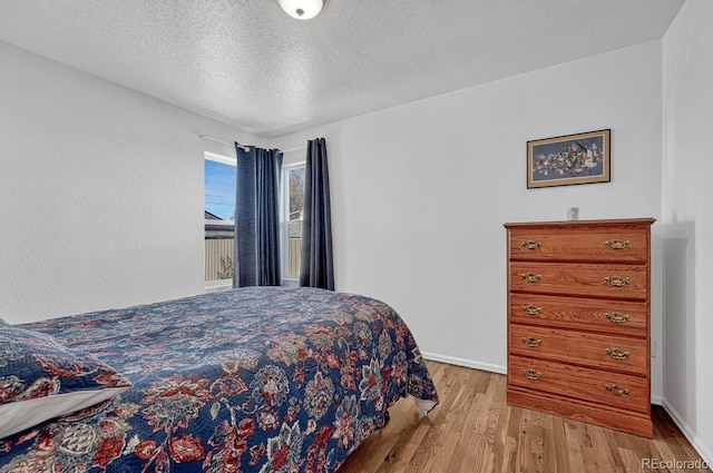 bedroom with light hardwood / wood-style flooring and a textured ceiling