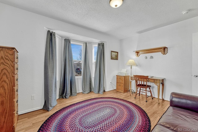 living area with hardwood / wood-style floors and a textured ceiling