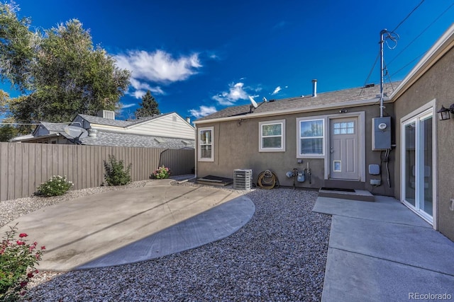 rear view of property with cooling unit and a patio area