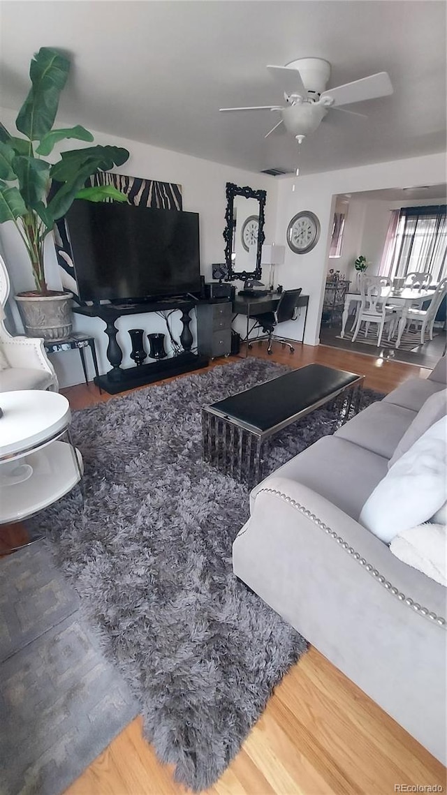 living area featuring ceiling fan and wood finished floors