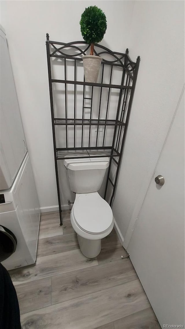 bathroom with baseboards, toilet, and wood finished floors