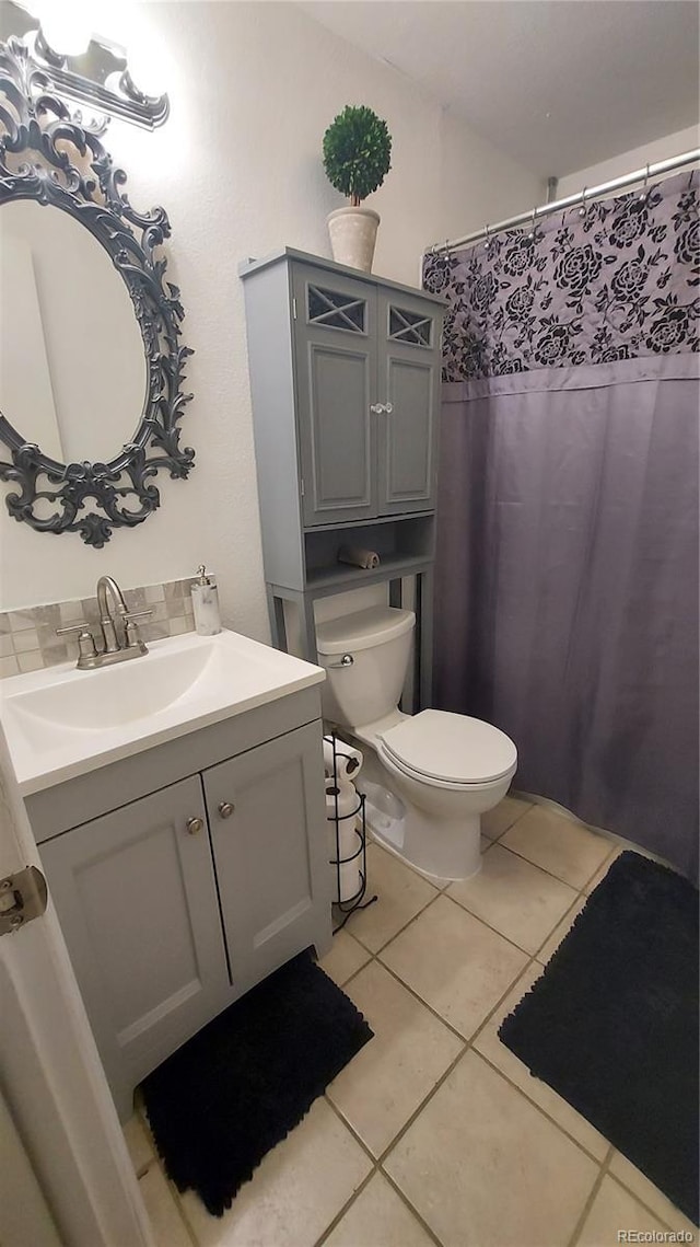 full bathroom with vanity, tile patterned floors, curtained shower, and toilet