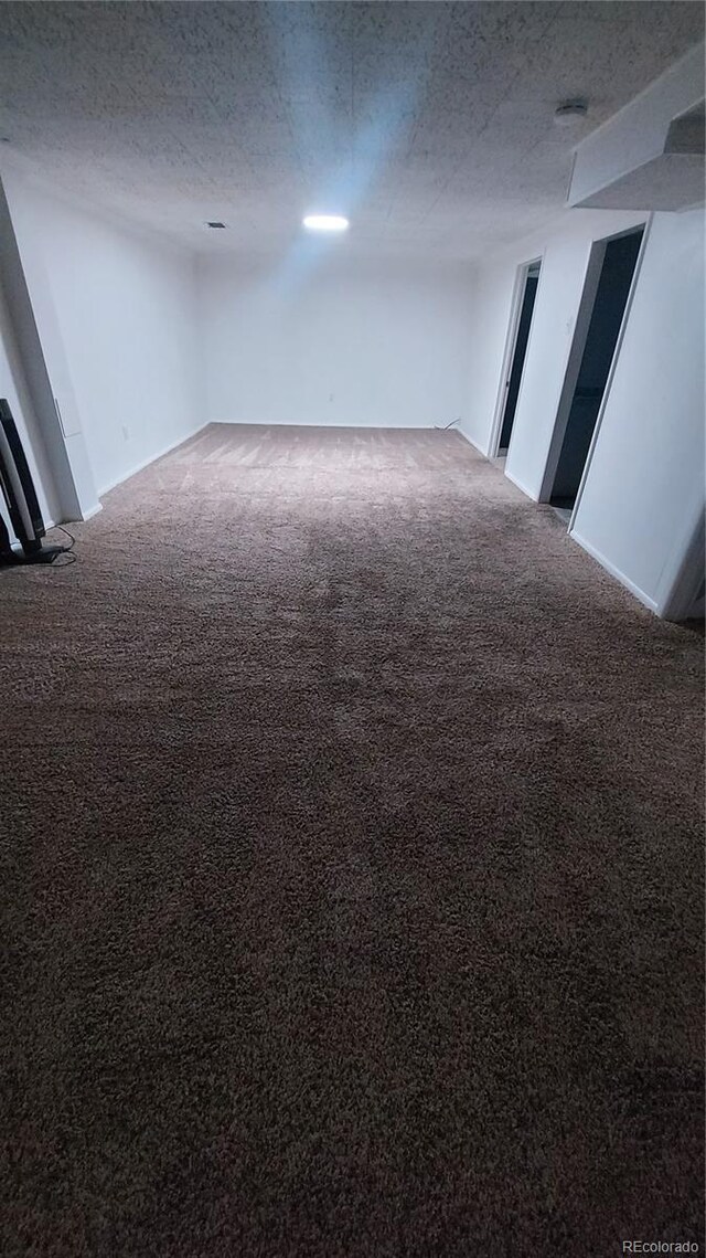 carpeted spare room with a textured ceiling