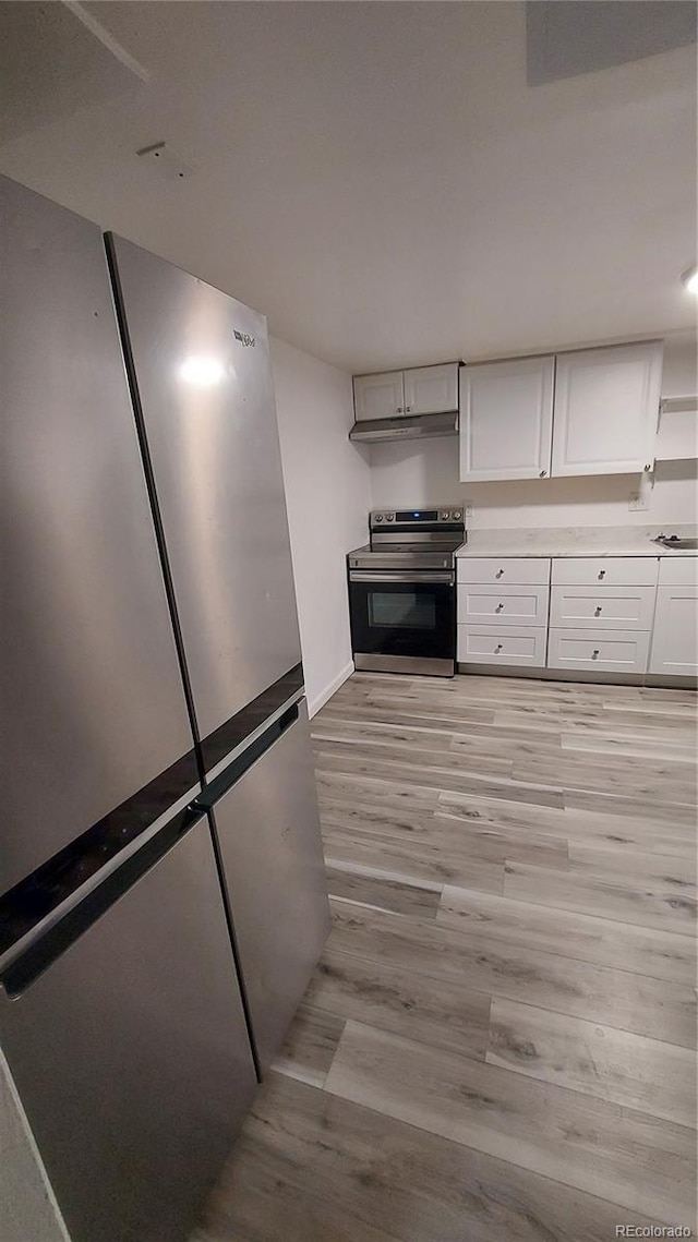 kitchen featuring open shelves, light wood-style flooring, stainless steel appliances, light countertops, and white cabinetry