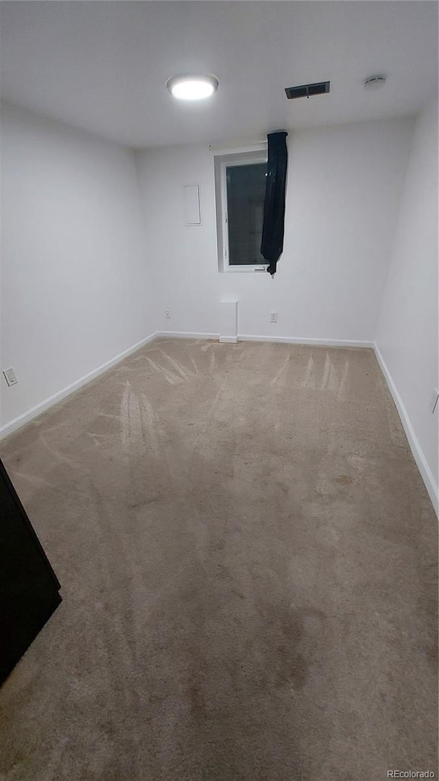 spare room with visible vents, carpet floors, and baseboards