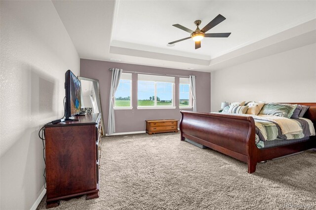 3434 Antelope Ridge Trl, Parker, CO 80138 - carpeted bedroom featuring a tray ceiling, baseboards, ceiling fan, and ornamental molding