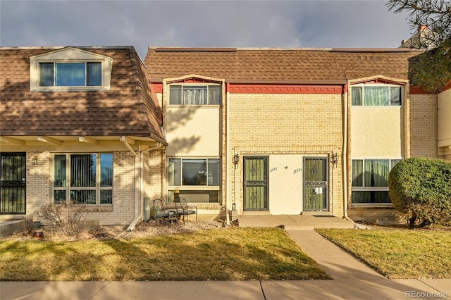 townhome / multi-family property featuring a front yard and a patio area