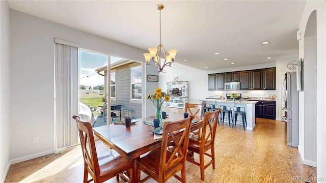 dining space featuring a chandelier and light hardwood / wood-style floors