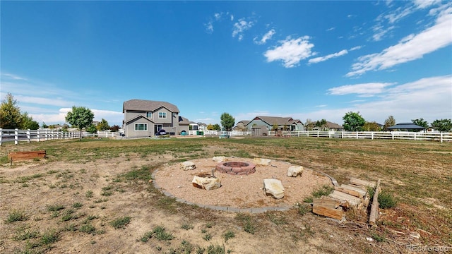 view of yard with an outdoor fire pit and a rural view