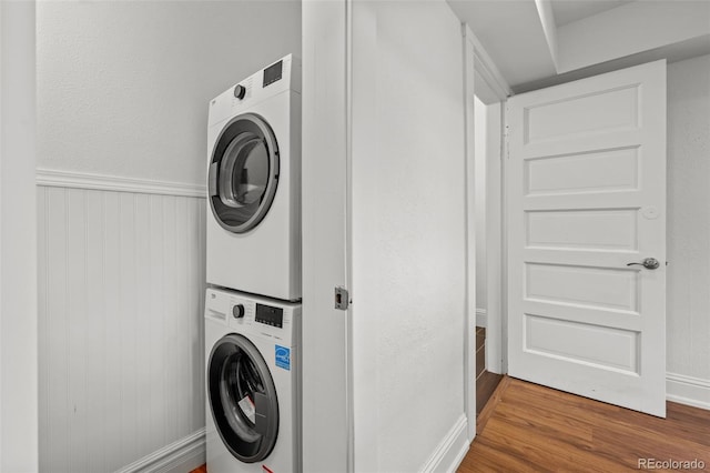 613 Pine St, Boulder, CO 80302 - laundry room featuring laundry area, stacked washer / dryer, wood finished floors, and a wainscoted wall