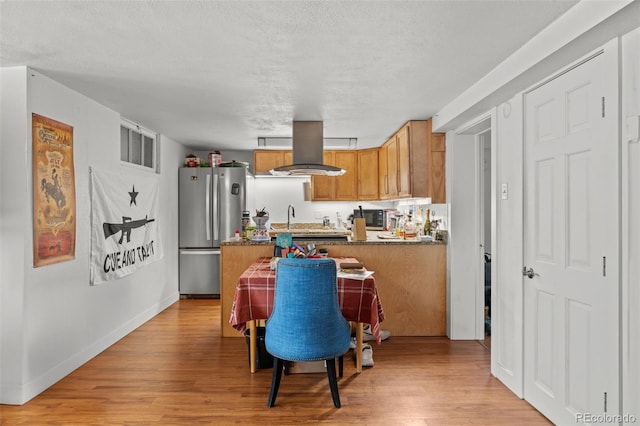 613 Pine St, Boulder, CO 80302 - kitchen featuring light wood finished floors, island exhaust hood, freestanding refrigerator, and a textured ceiling
