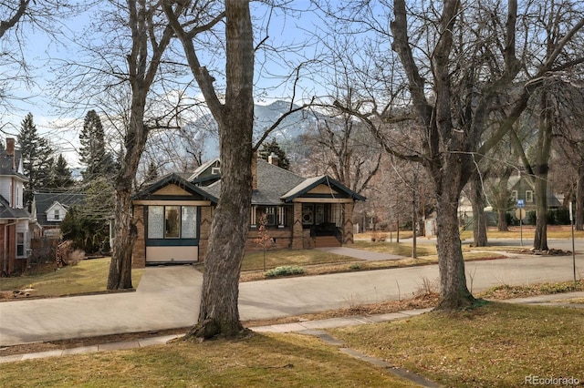 613 Pine St, Boulder, CO 80302 - view of front of home featuring a front lawn, curved driveway, roof with shingles, and a chimney