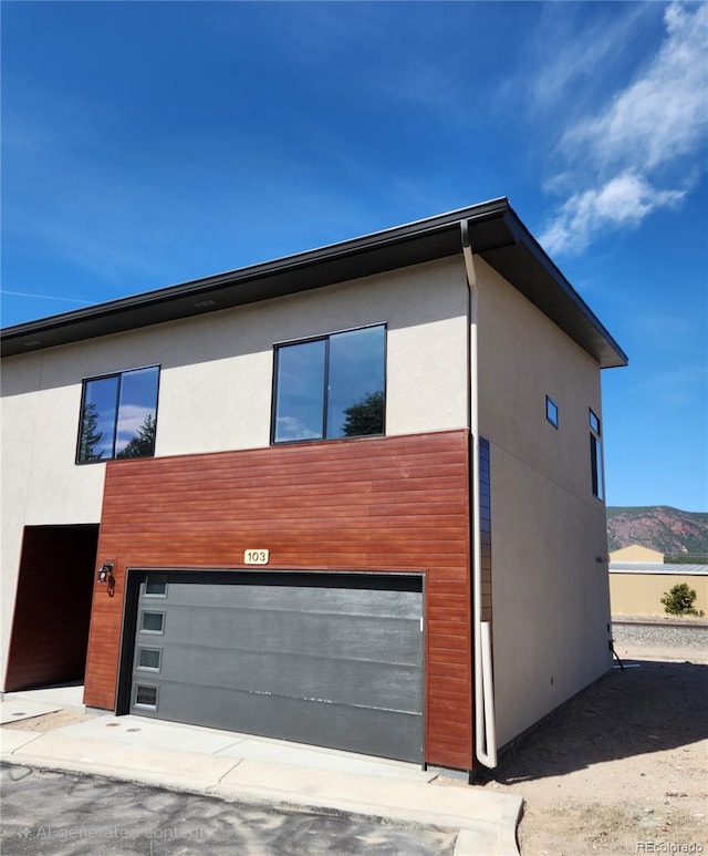241 N Front St Unit 103, Monument, CO 80132 - view of side of home featuring a garage, stucco siding, and a mountain view