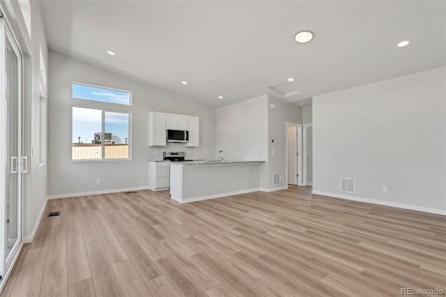 241 N Front St Unit 103, Monument, CO 80132 - unfurnished living room with light wood-type flooring, baseboards, vaulted ceiling, and visible vents
