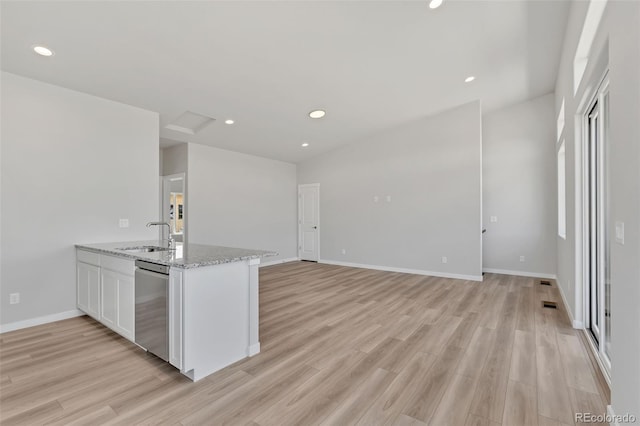 241 N Front St Unit 103, Monument, CO 80132 - kitchen with white cabinets, stainless steel dishwasher, a sink, and light wood-style flooring
