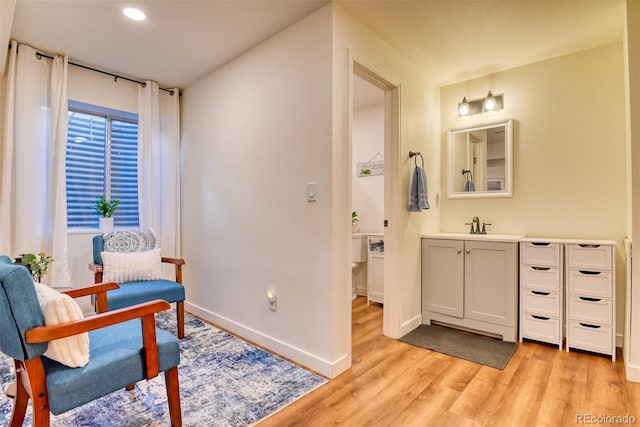 sitting room featuring sink and light wood-type flooring