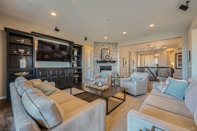 living area with recessed lighting, a chandelier, and a fireplace