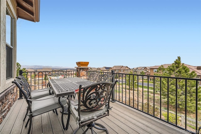 wooden deck with a residential view and outdoor dining space