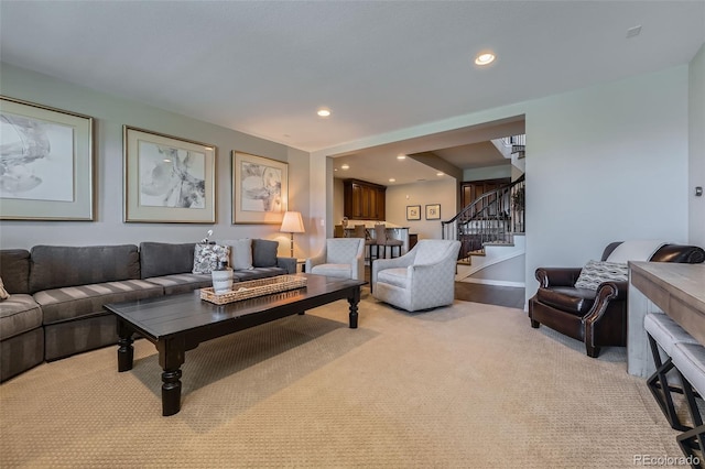 living area with stairs, recessed lighting, baseboards, and light carpet
