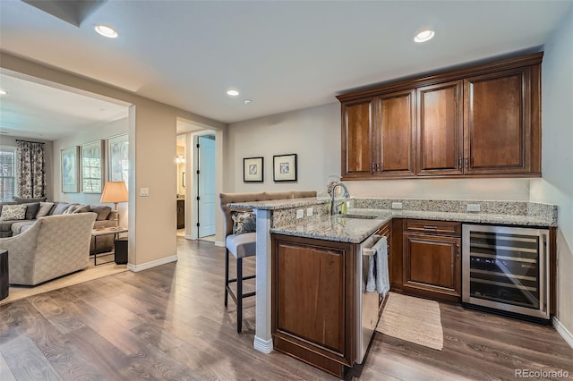 bar featuring dark wood-style flooring, dishwasher, a sink, beverage cooler, and recessed lighting