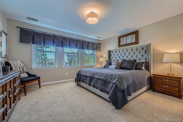 bedroom with baseboards, visible vents, and light carpet