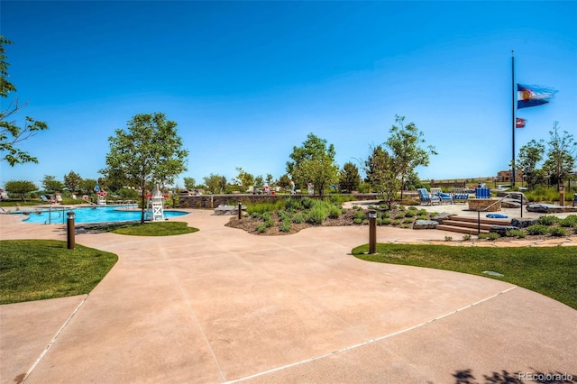 view of community with a swimming pool and a patio area
