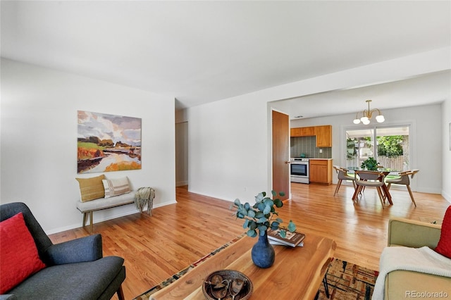 12162 W Dakota Dr, Lakewood, CO 80228 - living room featuring a chandelier, light wood finished floors, and baseboards