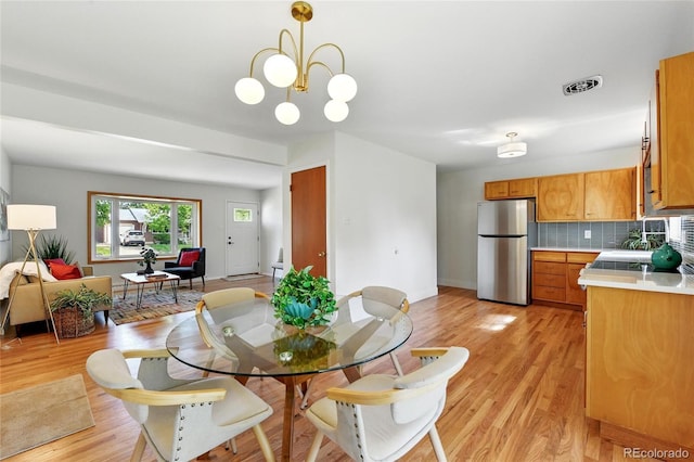 12162 W Dakota Dr, Lakewood, CO 80228 - dining space featuring light wood-style floors, baseboards, and a chandelier