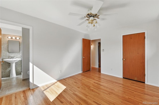 12162 W Dakota Dr, Lakewood, CO 80228 - unfurnished bedroom with wood finished floors, ensuite bath, baseboards, a sink, and a ceiling fan