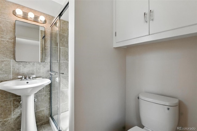 12162 W Dakota Dr, Lakewood, CO 80228 - full bathroom with tile walls, a stall shower, toilet, and a sink