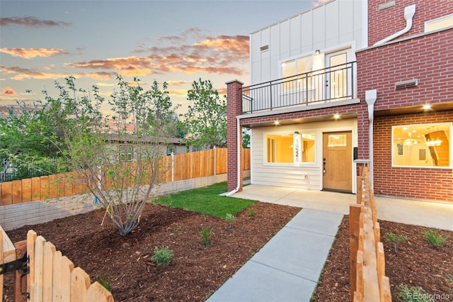 1046 N Knox Ct, Denver, CO 80204 - view of front facade featuring a balcony, a fenced backyard, and a patio