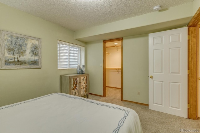 6041 Pioneer Mesa Dr, Colorado Springs, CO 80923 - carpeted bedroom featuring a textured ceiling, a walk in closet, and a closet