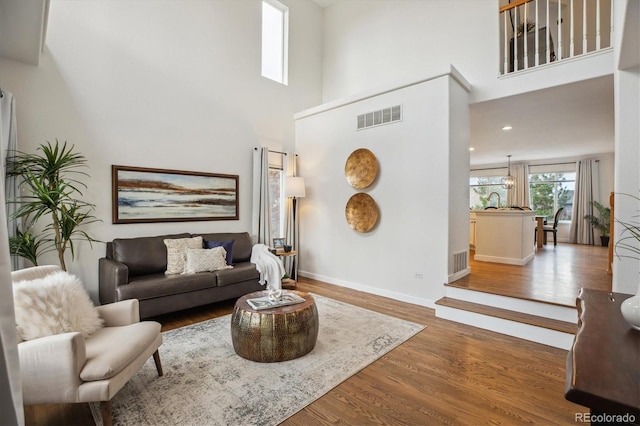 4526 Lyndenwood Pt, Highlands Ranch, CO 80130 - living room featuring wood finished floors, a high ceiling, and baseboards