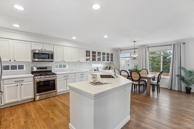 4526 Lyndenwood Pt, Highlands Ranch, CO 80130 - kitchen with stainless steel appliances, a sink, light wood-style flooring, white cabinetry, and light countertops