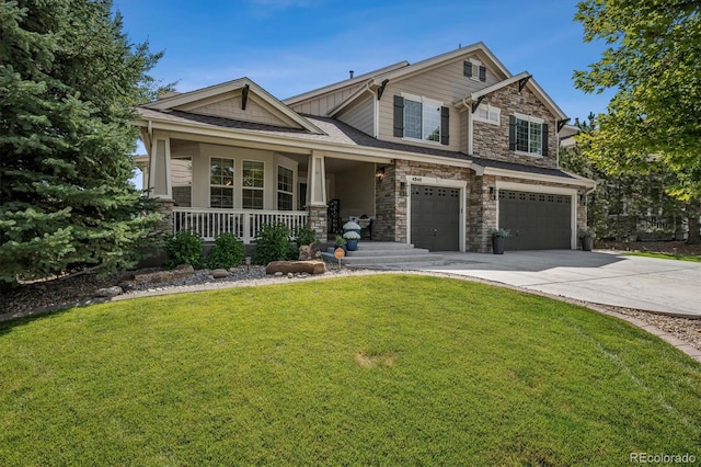 craftsman-style home with driveway, stone siding, an attached garage, a porch, and a front yard